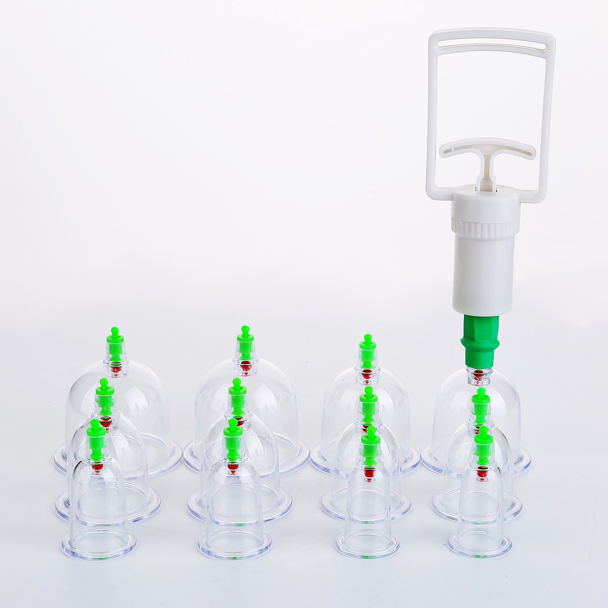 Cupping therapy set with clear cups and green handles on a white background